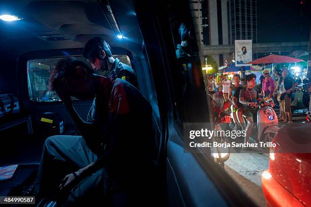 Pilapon volunteer, 14-years-old, rests inside the ambulance after a traffic accident on April 14, 2014 in Bangkok, Thailand. The body collectors,...