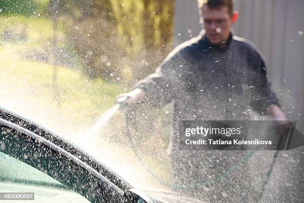 man washing his car in front of his house - car scandinavia stock pictures, royalty-free photos & images