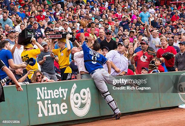 Drew Butera of the Kansas City Royals unsuccessfully leaps into the stands for a foul ball during the first inning against the Boston Red Sox at...