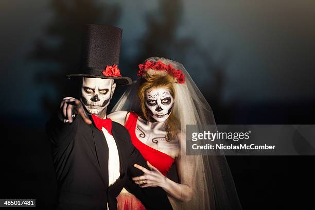 couple in halloween skeleton bridal costume does threatening gesture - stage costume stock pictures, royalty-free photos & images