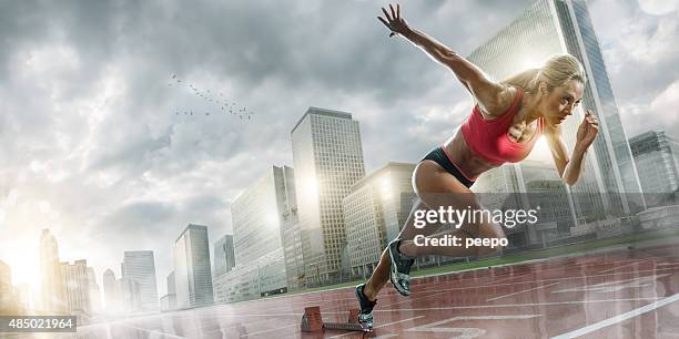 woman athlete sprinting in wet city - track starting block stock pictures, royalty-free photos & images