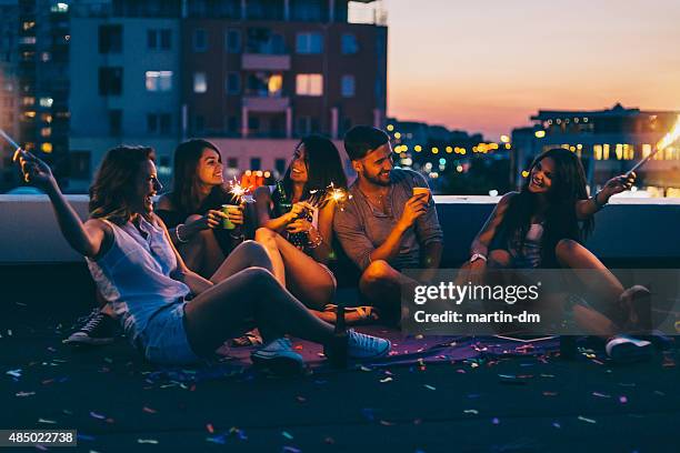 best friends on a rooftop party - urban rooftop terrace stock pictures, royalty-free photos & images
