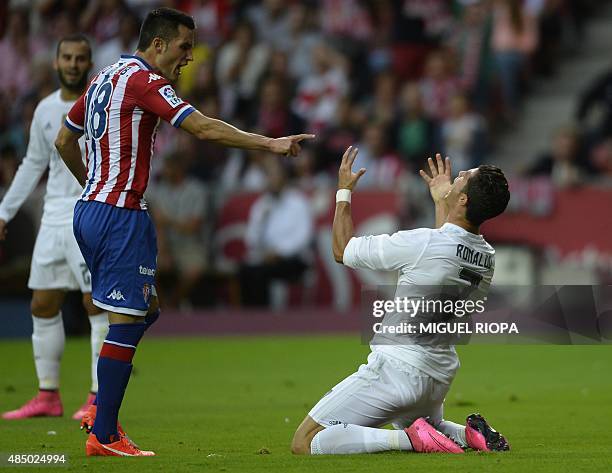Real Madrid's Portuguese forward Cristiano Ronaldo reacts next to Sporting Gijon's midfielder Carlos Carmona during the Spanish league football match...