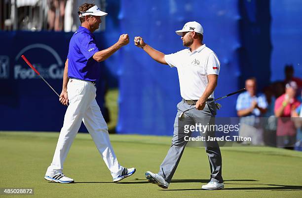 Davis Love III congatulates Ryan Moore after Moore holed out for birdie from off of the green on the 17th hole during the final round of the Wyndham...