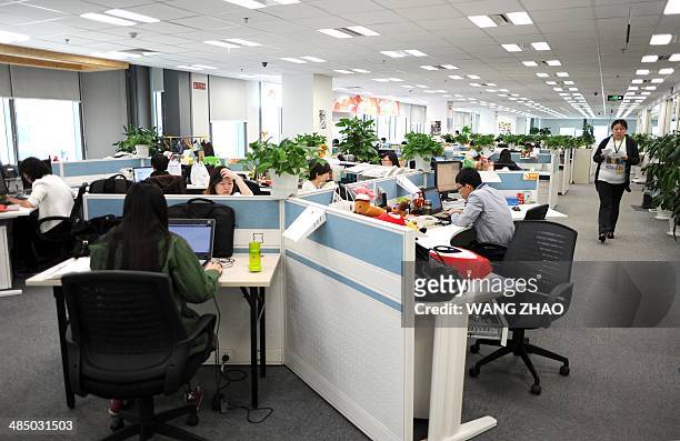 Employees work in an office of Sina Weibo, widely known as China's version of Twitter, in Beijing on April 16. Sina Weibo is set to go public in the...