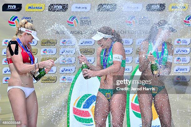 Kerri Walsh Jennings , Larissa Franca and Talita Antunes of Team Brazil celebrate on the podium with champagne at the ASICS World Series of...