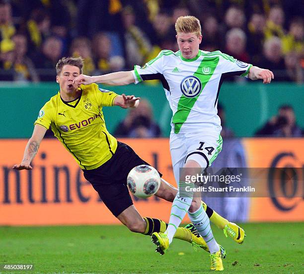 Erik Durm of Dortmund is challenged by Kevin de Bruyne of Wolfsburg during the DFB Cup semi final match between Borussia Dortmund and VfL Wolfsburg...