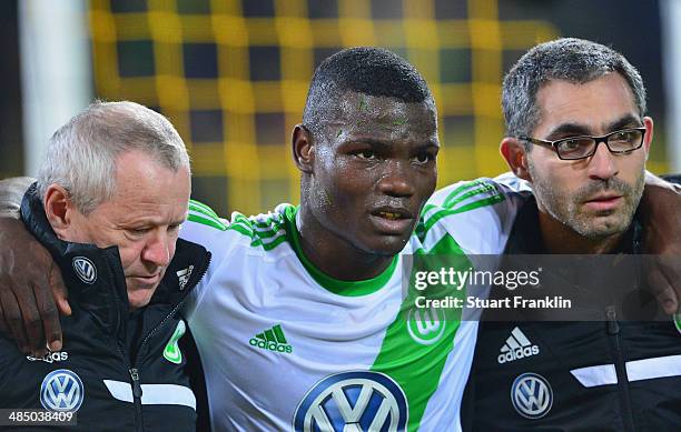 Bernard Malanda-Adje of Wolfsburg is carried off during the DFB Cup semi final match between Borussia Dortmund and VfL Wolfsburg at Signal Iduna Park...