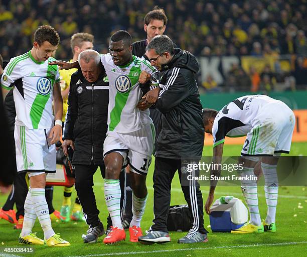 Bernard Malanda-Adje of Wolfsburg is carried off during the DFB Cup semi final match between Borussia Dortmund and VfL Wolfsburg at Signal Iduna Park...