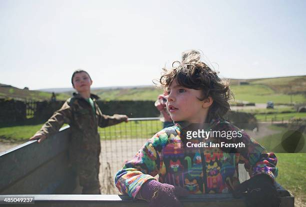 Edith Owen rides in a trailer towed behind a quad bike at Ravenseat, the farm of the Yorkshire Shepherdess Amanda Owen on April 15, 2014 near Kirkby...