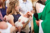 Mother hold baby on ceremony of child christening in church