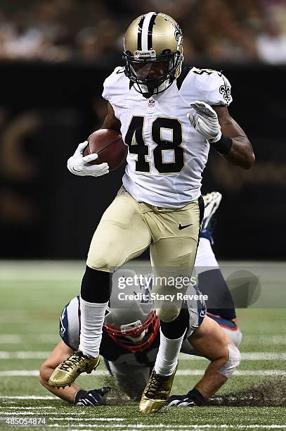 Marcus Murphy of the New Orleans Saints avoids a tackle by Joe Cardona of the New England Patriots during a preseason game at the Mercedes-Benz...
