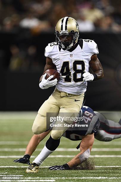 Marcus Murphy of the New Orleans Saints avoids a tackle by Joe Cardona of the New England Patriots during a preseason game at the Mercedes-Benz...