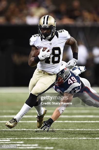 Marcus Murphy of the New Orleans Saints avoids a tackle by Joe Cardona of the New England Patriots during a preseason game at the Mercedes-Benz...