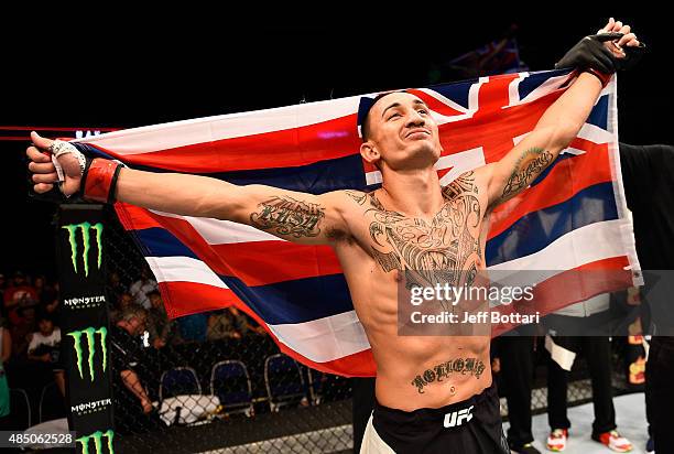 Max Holloway of the United States celebrates after his victory over Charles Oliveira in their featherweight bout during the UFC event at the SaskTel...