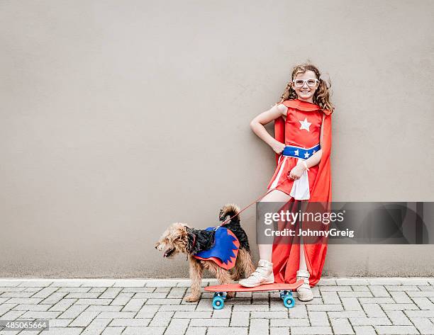 little superhero girl with her dog and skateboard - dog skateboard stock pictures, royalty-free photos & images