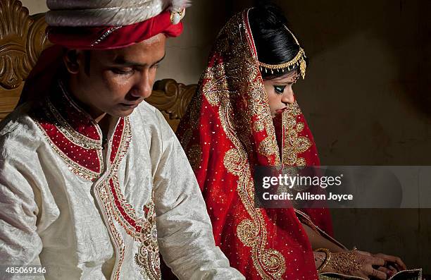 Year old Mohammad Hasamur Rahman poses for photographs with his new bride, 15 year old Nasoin Akhter, August 20, 2015 in Manikganj, Bangladesh. In...