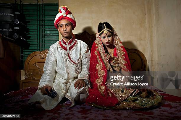Year old Mohammad Hasamur Rahman poses for photographs with his new bride, 15 year old Nasoin Akhter, August 20, 2015 in Manikganj, Bangladesh. In...
