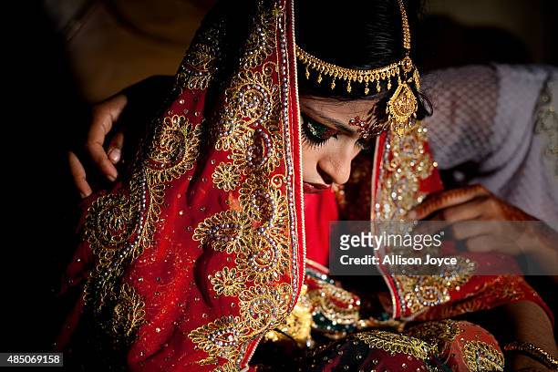 Year old Nasoin Akhter is consoled by a friend on the day of her wedding to a 32 year old man, August 20, 2015 in Manikganj, Bangladesh. In June of...