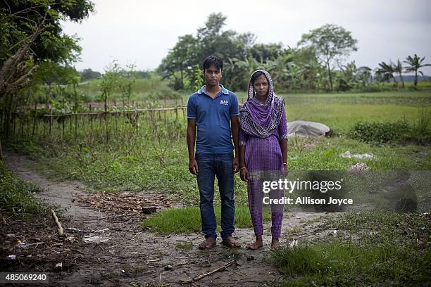 Year old Mohammad Sujon Mia stands for a photo beside his wife, 14 year old Mousammat Akhi Akhter in their home August 19, 2015 in Manikganj,...