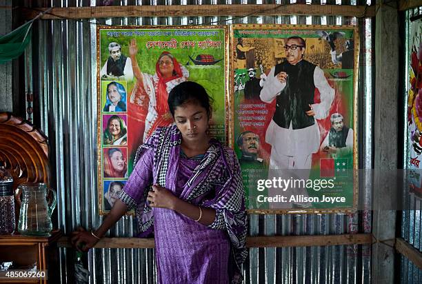 Year old Mousammat Akhi Akhter stands against a photograph of Bangladesh Prime Minister Sheikh Hasina and her father, founding leader of Bangaldesh,...