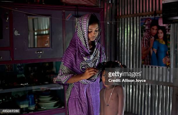 Year old Mousammat Akhi Akhter does a relatives's hair in her home August 19, 2015 in Manikganj, Bangladesh. Last year, when she was only 13, Akhi...
