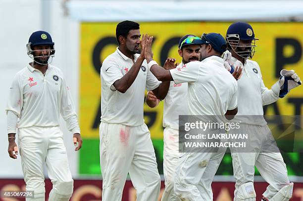 Indian cricketer Ravichandran Ashwin celebrates with his teammates after he dismissed Sri Lankan cricketer Dinesh Chandimal during the final day of...