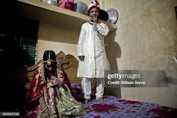 Year old Mohammad Hasamur Rahman stands on a bed above his new bride, 15 year old Nasoin Akhter, August 20, 2015 in Manikganj, Bangladesh. In June of...