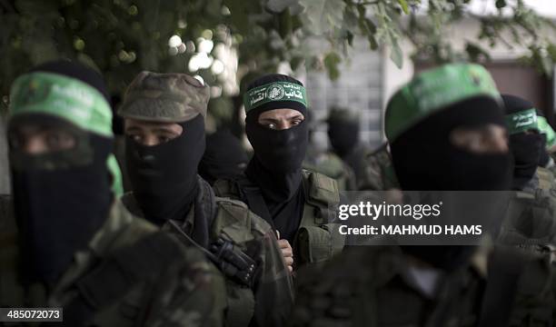 Hamas militants take part in a funeral of three comrades who were killed in an explosion, in the al-Nusairat refugee camp, in central Gaza Strip, on...