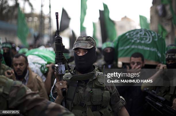 Mourners carry the body two of three of Hamas militants who were killed in an explosion, during their funeral in the al-Nusairat refugee camp, in...
