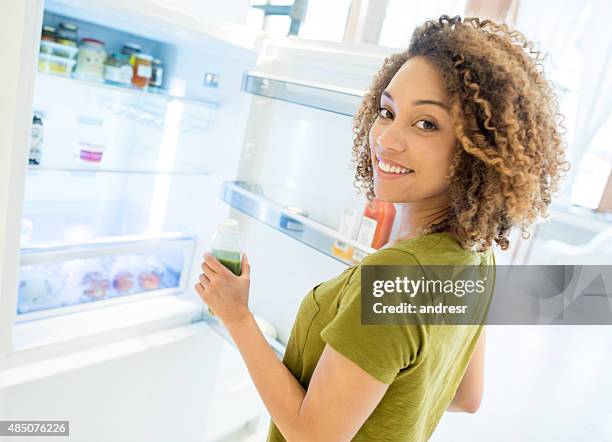 woman opening the fridge - beverage fridge stock pictures, royalty-free photos & images