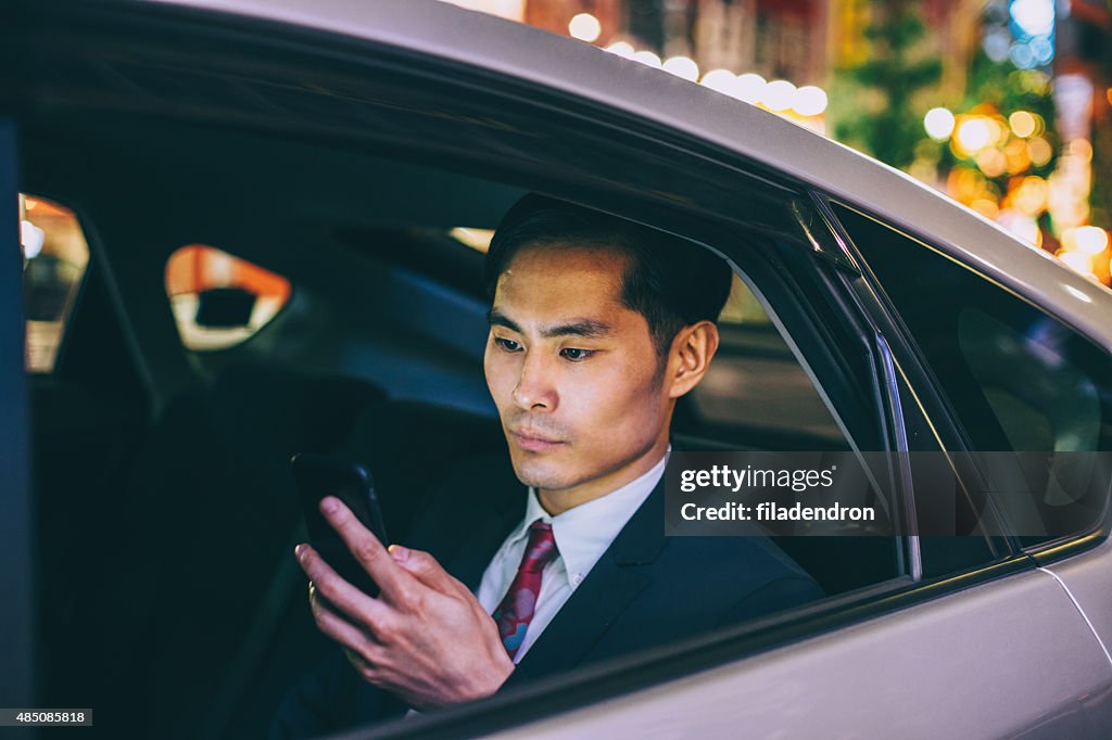 Businessman texting in a car