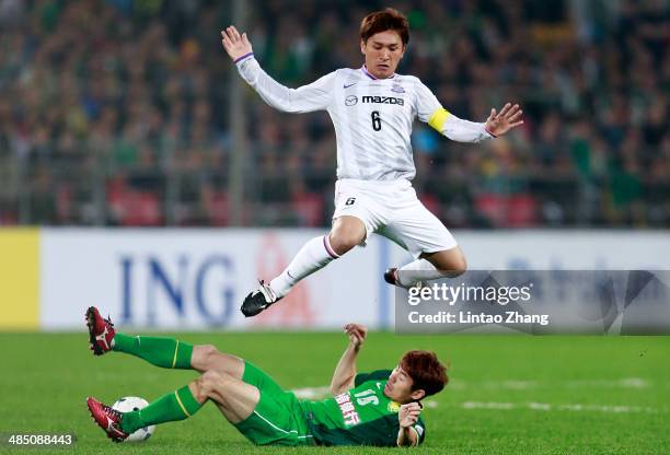 Toshihiro Aoyama of Sanfrecce Hiroshima challenges He Dae Sung of Beijing Guo'an during the AFC Champions match between Sanfrecce Hiroshima and...