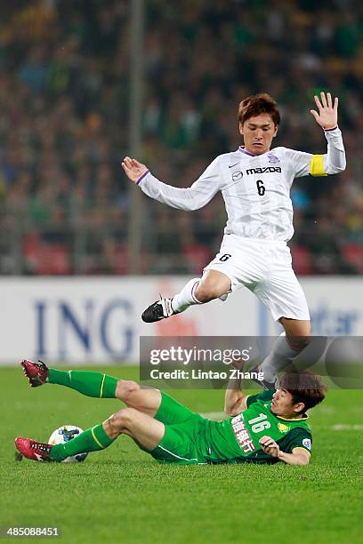 Toshihiro Aoyama of Sanfrecce Hiroshima challenges He Dae Sung of Beijing Guo'an during the AFC Champions match between Sanfrecce Hiroshima and...