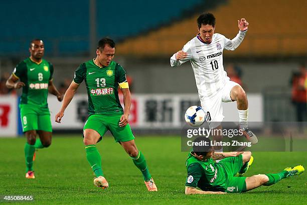 Yojiro Takahagi of Sanfrecce Hiroshima challenges Zhou Ting of Beijing Guo'an during the AFC Champions match between Sanfrecce Hiroshima and Beijing...