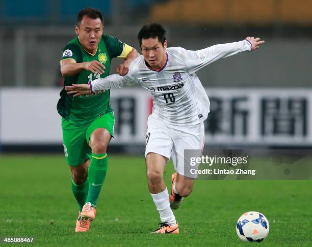 Yojiro Takahagi of Sanfrecce Hiroshima challenges Xu Yunlong of Beijing Guo'an during the AFC Champions match between Sanfrecce Hiroshima and Beijing...