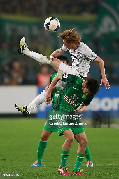 Naoki Ishihara of Sanfrecce Hiroshima competes for an aerial ball with Zhao Hejing of Beijing Guo'an during the AFC Champions match between Sanfrecce...