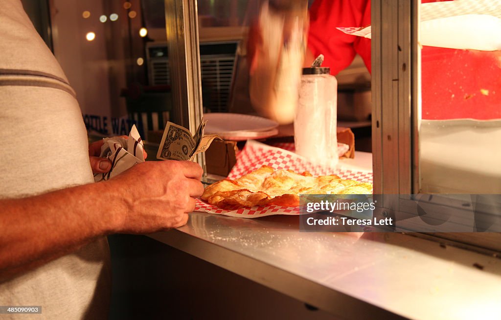 Man buying elephant ear at carnival