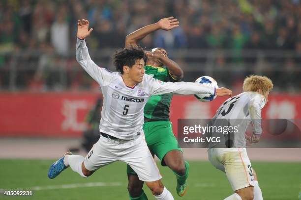 Joffre Guerron of Beijing Guo'an and Kazuhiko Chiba of Sanfrecce Hiroshima battle for the ball during the Asian Champions League match between...