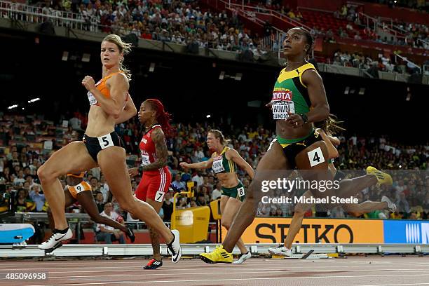 Dafne Schippers of the Netherlands and Veronica Campbell-Brown of Jamaica cross the finish line in the Women's 100 metres semi-final during day three...