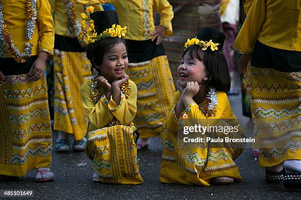 Young Burmese dancers wearing traditional clothing laugh as they wait to take part in the closing ceremony during festivities on the fourth day of...