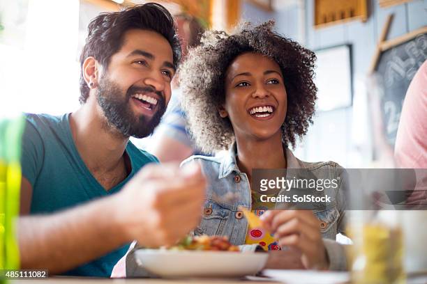 young couple eating in a bar - people eating in bistro stockfoto's en -beelden