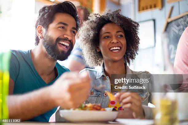 young couple eating in a bar - nacho chip stock pictures, royalty-free photos & images