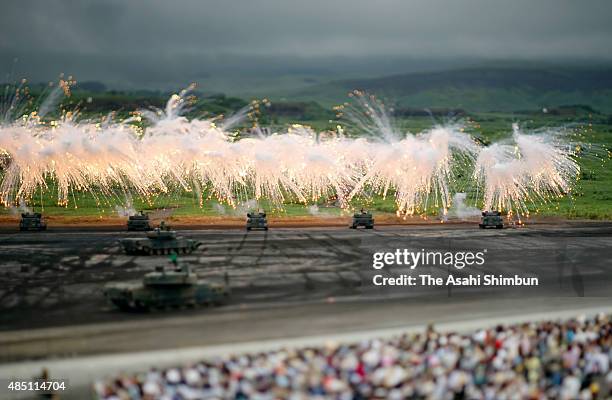 Japan Ground Self-Defence Force tanks send up a smoke screen during the annual live firing exercise at the JGSDF's East Fuji Maneuver Area on August...