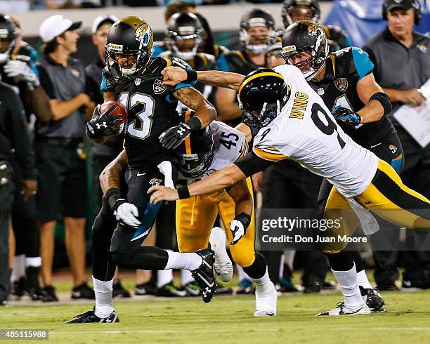 Wide Receiver Rashad Greene of the Jacksonville Jaguars is tackled by Fullback Roosevelt Nix and Punter Brad Wing of the Pittsburgh Steelers during a...