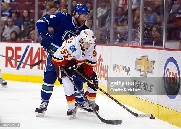 Johnny Gaudreau of the Calgary Flames is tied up by Ryan Stanton of the Vancouver Canucks during NHL action against the Vancouver Canucks on April...