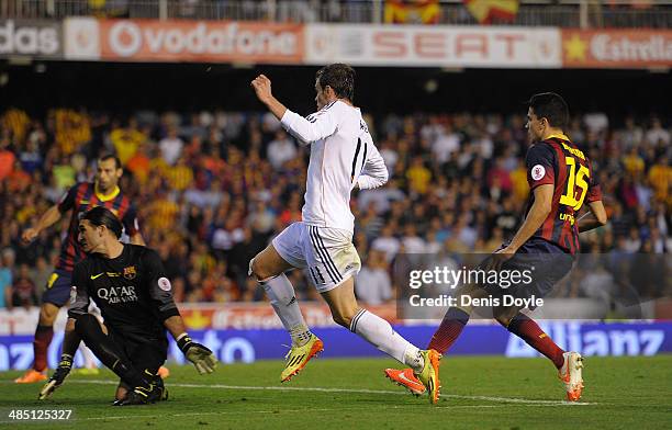 Gareth Bale of Real Madrid beats Marc Bartra and Jose Pinto of Barcelona to score Real's 2nd goal during the Copa del Rey Final between Real Madrid...