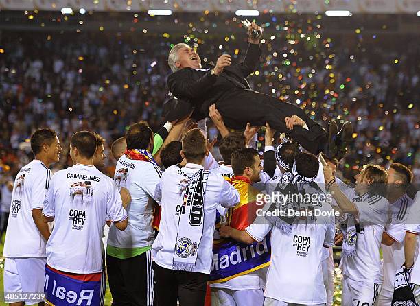 Head coach Carlo Ancelotti of Real Madrid is thrown into the air by his players after Real beat Barcelona 2-1 in the Copa del Rey Final between Real...
