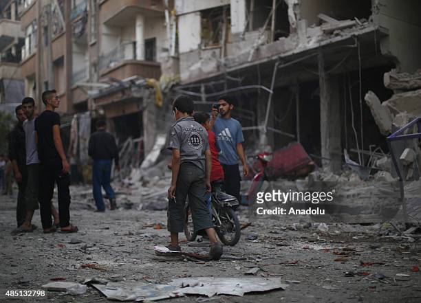 People inspect the attack site and try to recover their lives after Assad regime forces' air-strike staged to residential areas, in Douma District of...