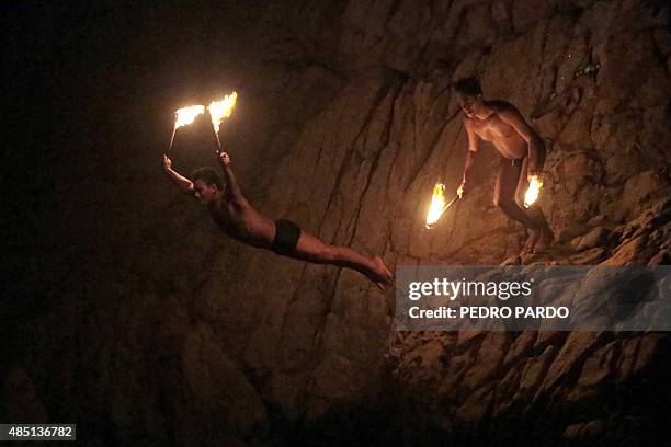 Cliff divers hold torches as they jump at La Quebrada in Acapulco, Mexico on August 14, 2015. The tradition of 'La Quebrada' goes back to 1934, when...